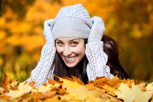 woman with hat and fall leaves