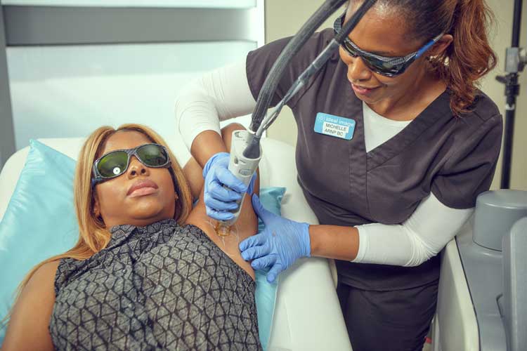 woman receiving laser hair removal treatment under arms