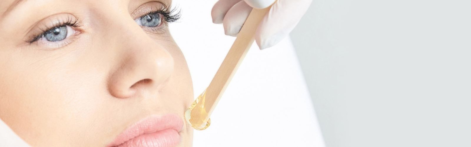 Woman with blue eyes receiving skin treatment.