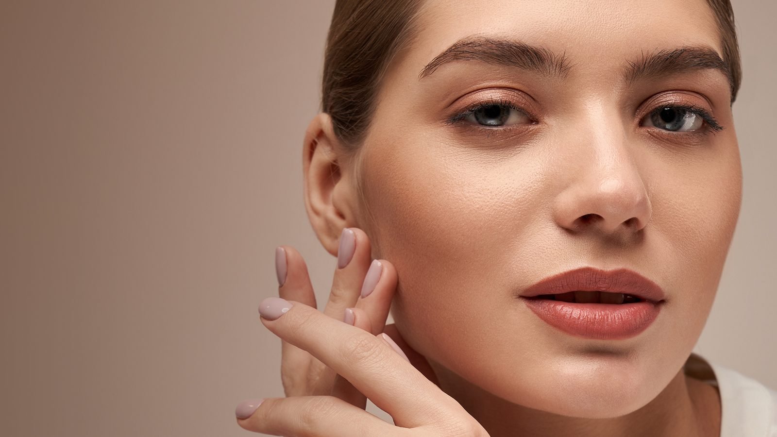 Closeup of woman's face holding her hands.