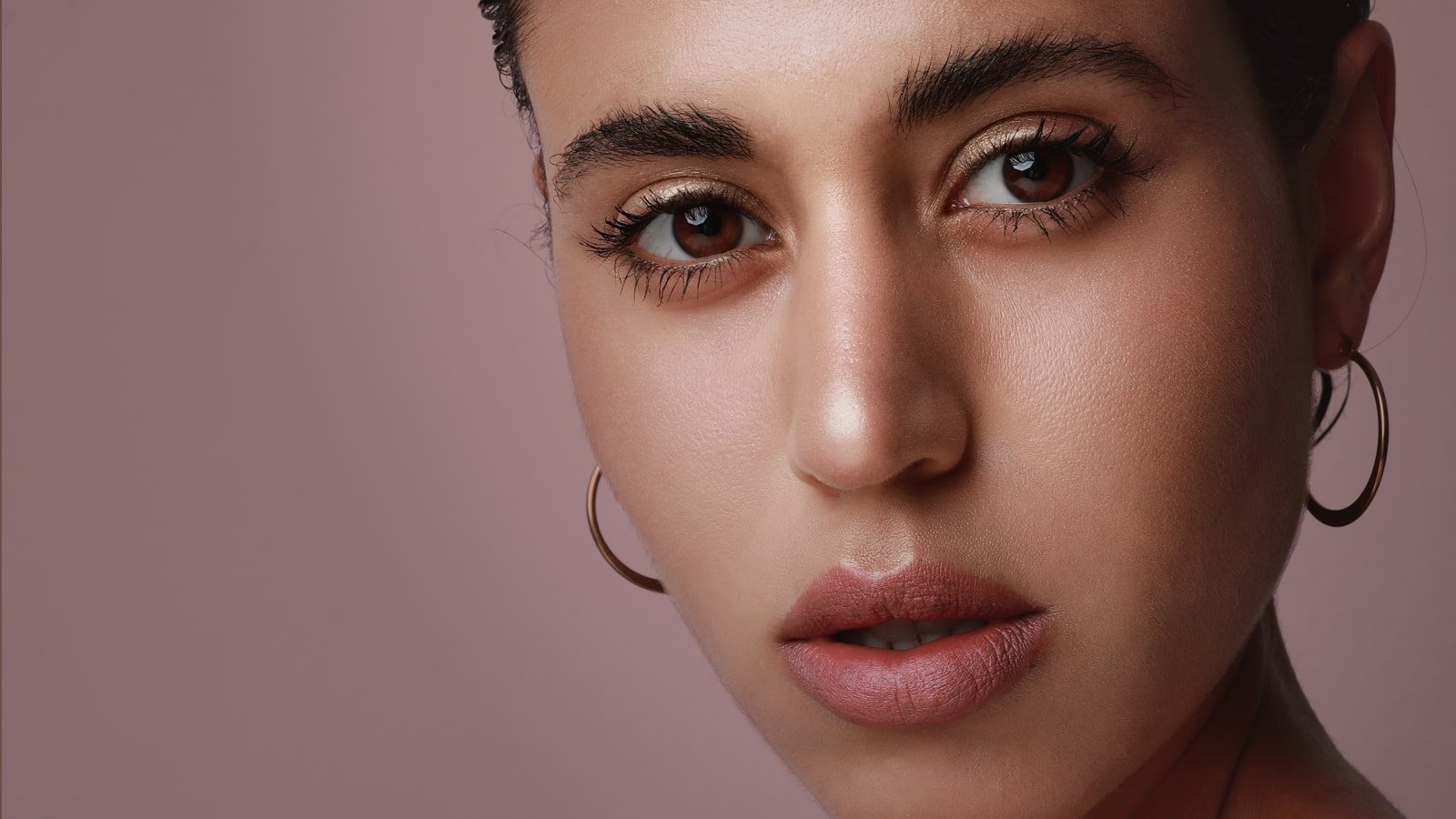 Woman with brown eyes wearing earrings.