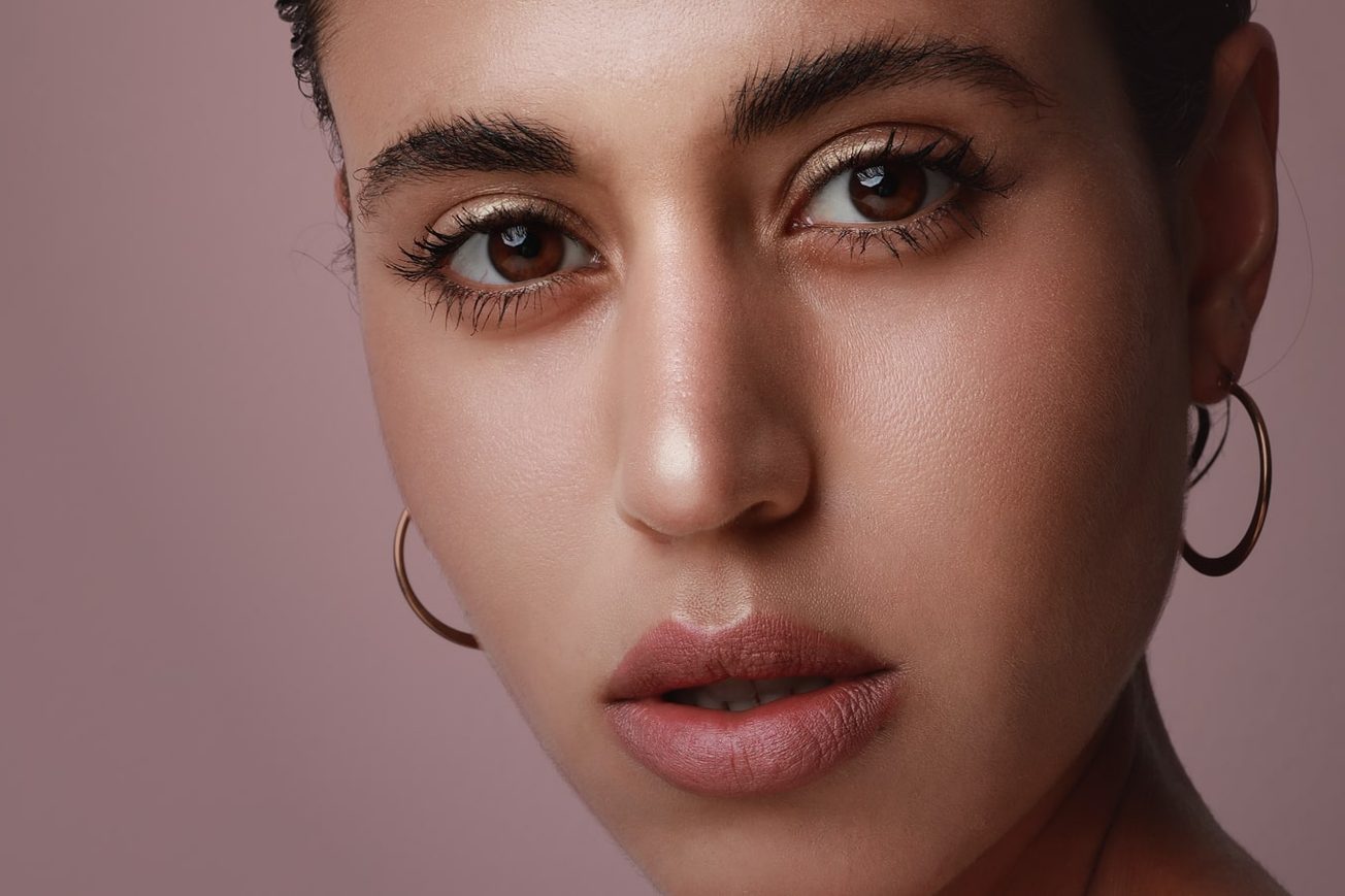 Woman with brown eyes wearing earrings.