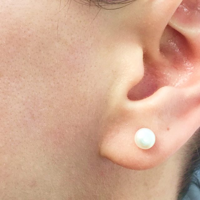 Side angle of a person's white earring.