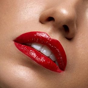 A closeup of a woman's lips wearing red lipstick.