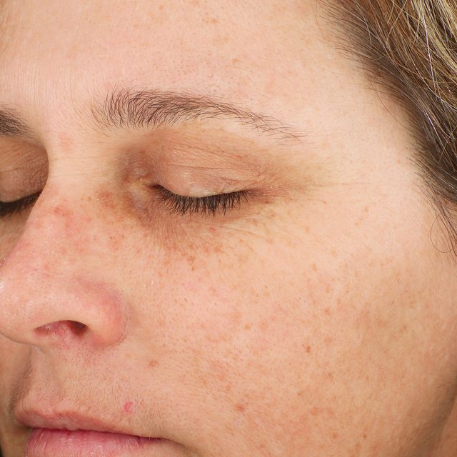 Closeup of a woman's face while her eyes are closed.