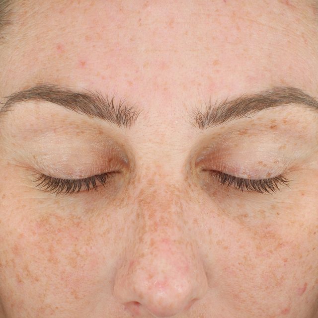 Closeup of a woman's face while her eyes are closed.