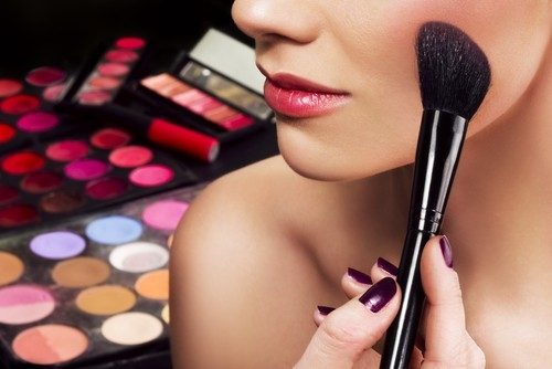 Closeup of a woman's face as she applied makeup to her cheek area