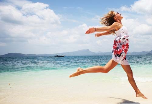 Woman with white colored sundress near the beach