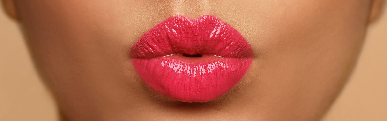 Closeup of a person's lips with bright pink lipstick.
