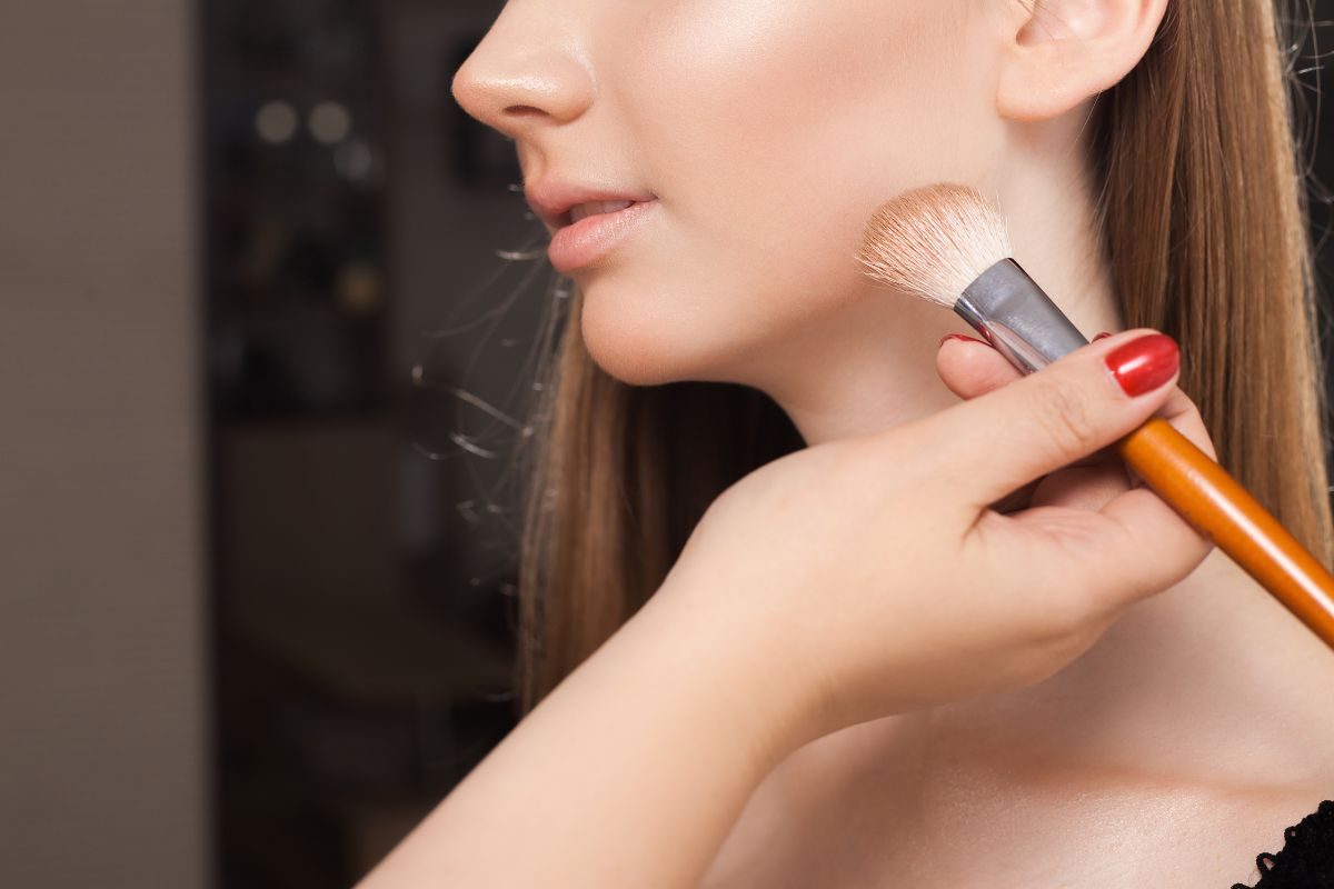 woman applying makeup to chin area