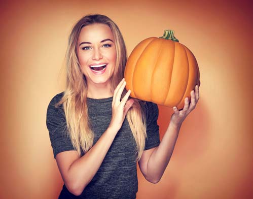 young woman holding pumpkin