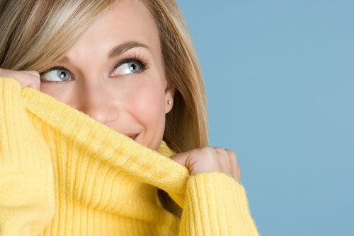 young woman peering out of sweater