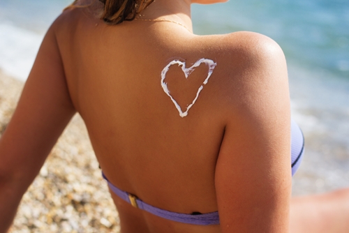 sunscreen on woman's shoulder in shape of a heart