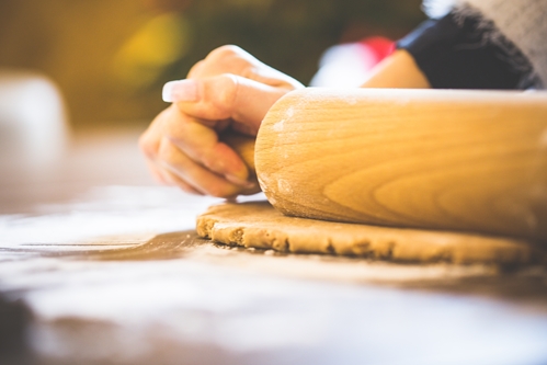 close up of rolling pin rolling dough