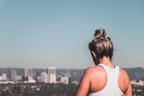 young woman with hair in bun overlooking tall buildings